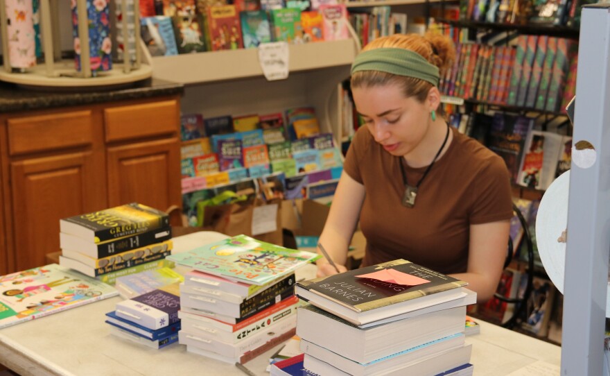 Staff member Aleta O’Driscoll writes tags for new books before they go on the shelf at Book Gallery West. The store also sells used books. (Kevin Perez/WUFT News)