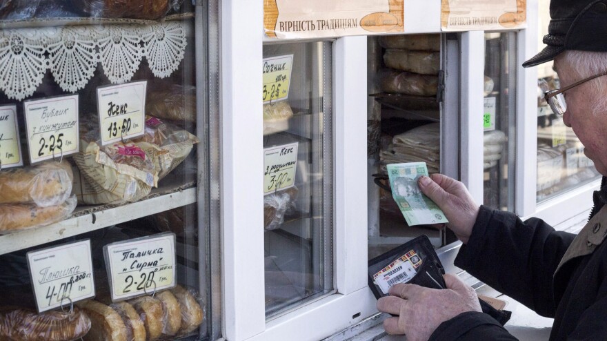 A customer pays for goods at a street kiosk in Kiev on Feb. 26.