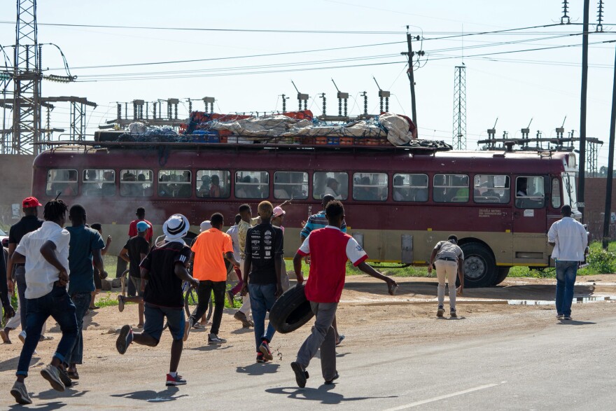 Protesters throw stones toward a bus that was alleged to be working during the national strike against the steep rise in fuel prices in January in Emakhandeni township, Bulawayo, Zimbabwe.