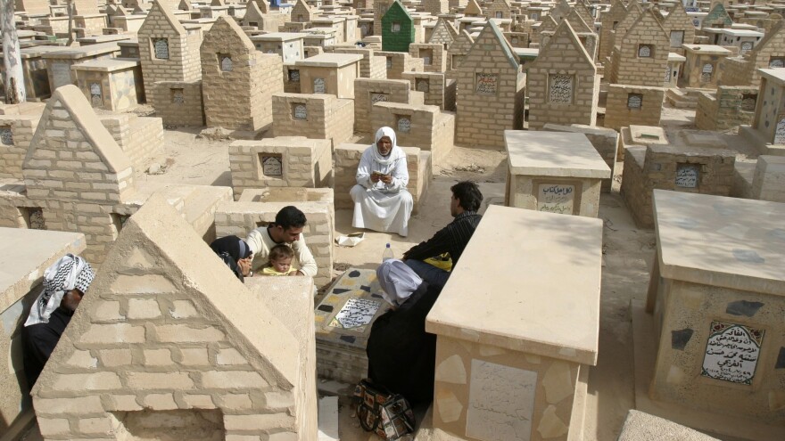 Residents visit the tomb of a  loved one at the New Kerbala cemetery in the holy city of Kerbala, Iraq, in 2007.