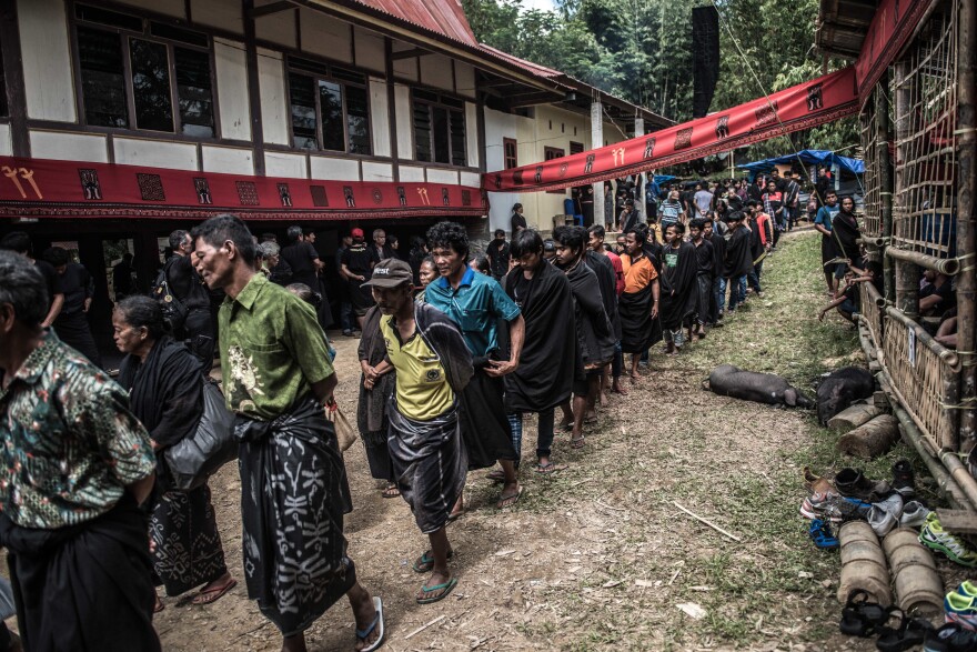 Guests arrive at the funeral of Lucas Ruruk in a village near Rantepao. The family characterizes it as a medium-size funeral — with well over 1,000 attendees.