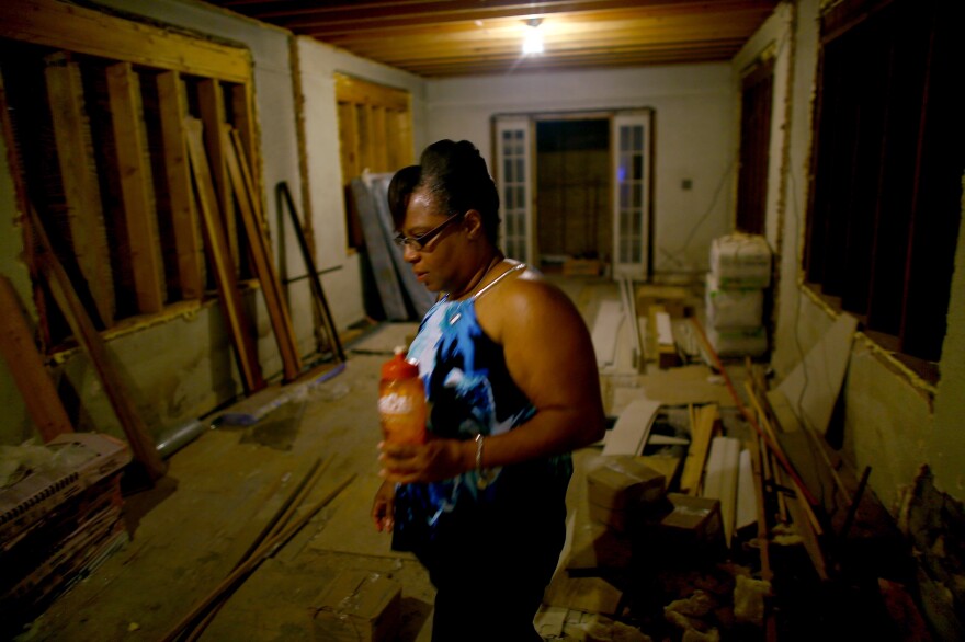 Angela Chalk walks through the still-unfinished ground floor of her home in the 7th Ward of New Orleans. Her current residence sits atop the old house, which is part of the new code for property owners who are rebuilding.