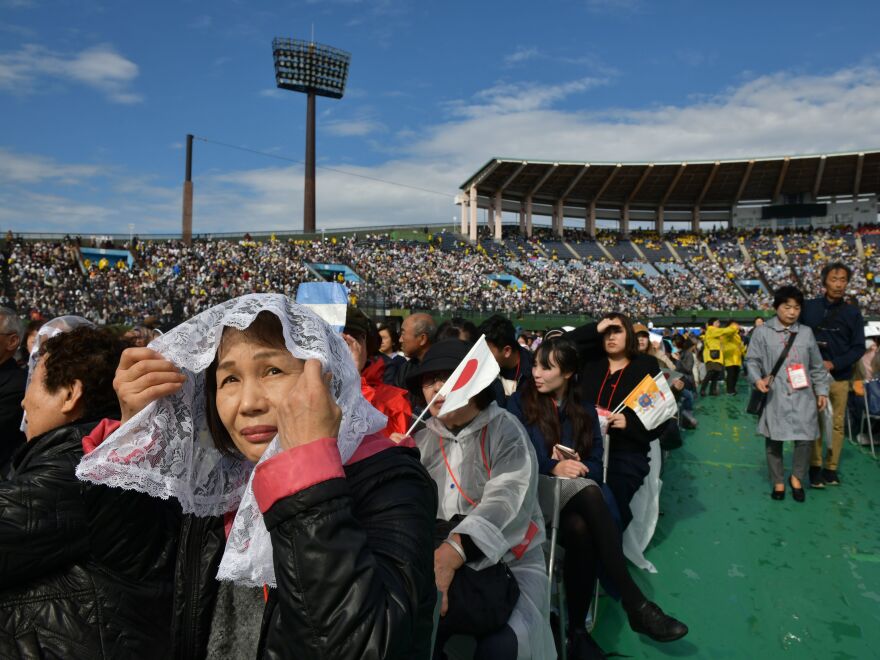 Attendees wait for a Holy Mass led by Pope Francis at a baseball stadium in Nagasaki on Sunday.