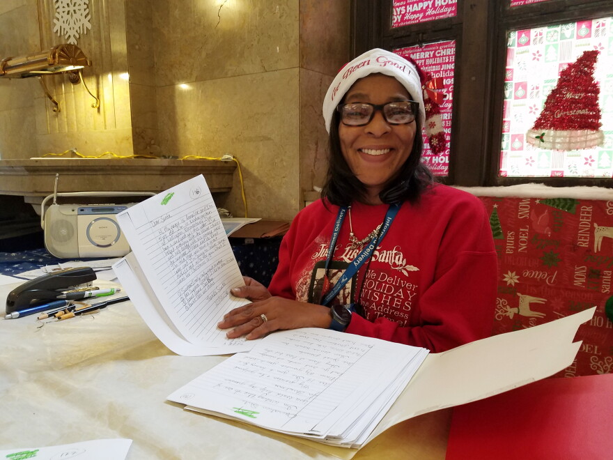 Post Office Quality of Working Life Coordinator Kimberly Davis holds some of the hundreds of letters sent to the post office this year seeking Santa's help for Christmas.
