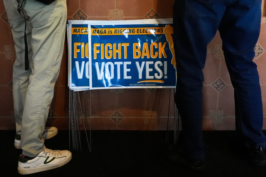 Signs in support of the Virginia redistricting referendum are seen as Jen Strozier and Doug Mock, members of the Goochland Democratic Committee, order lunch at GG's Pizza, Thursday, April 2, 2026, in Maiden, Va.