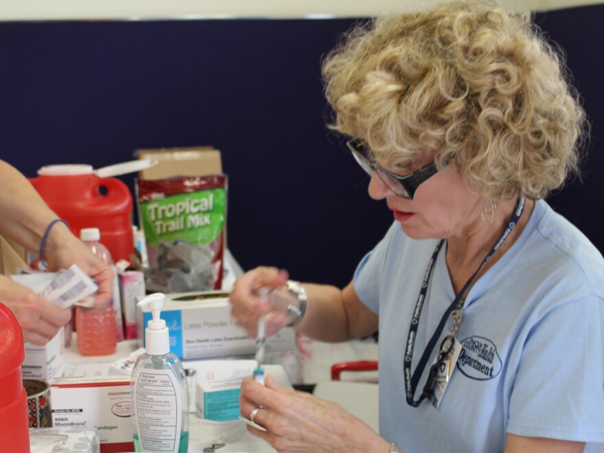 Jacqueline Fletcher readies a measles vaccine to give at a makeshift clinic in central Ohio. About 8,000 Amish people in the area have received measles vaccinations since April.