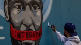 The artist Celos paints a mural in Downtown Los Angeles in protest against the death of George Floyd by police in Minneapolis. (Apu Gomes/AFP/Getty Images)