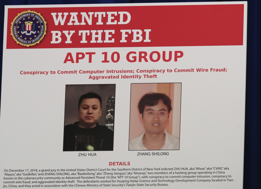 A Justice Department poster shows two Chinese citizens suspected of carrying out an extensive hacking campaign directed at dozens of U.S. tech companies. U.S. law enforcement says such cases are on the rise as China seeks to become a world leader in advanced technologies by 2025.