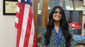 Peoria's new election commissioner Jessily Joseph stands in front of American flag
