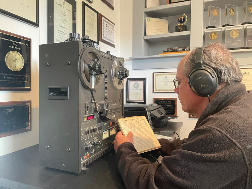 Man listening to reel-to-reel machine. 