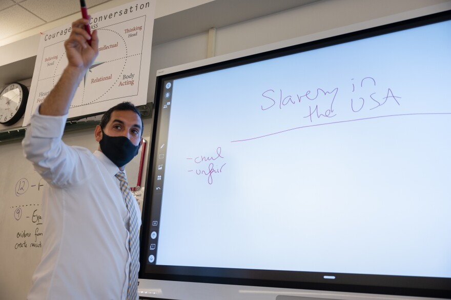 Adrian Solis teaches a Black and Latino history class at Abbott Technical High School in Danbury, Conn. The class’s curriculum is being piloted at 50 schools across the state after the state legislature passed a law requiring high schools to offer courses on African, Black, Puerto Rican, and Latino studies. He began the lesson by asking students to each share a single word that comes to mind when they see the phrase “Slavery in the USA.” 