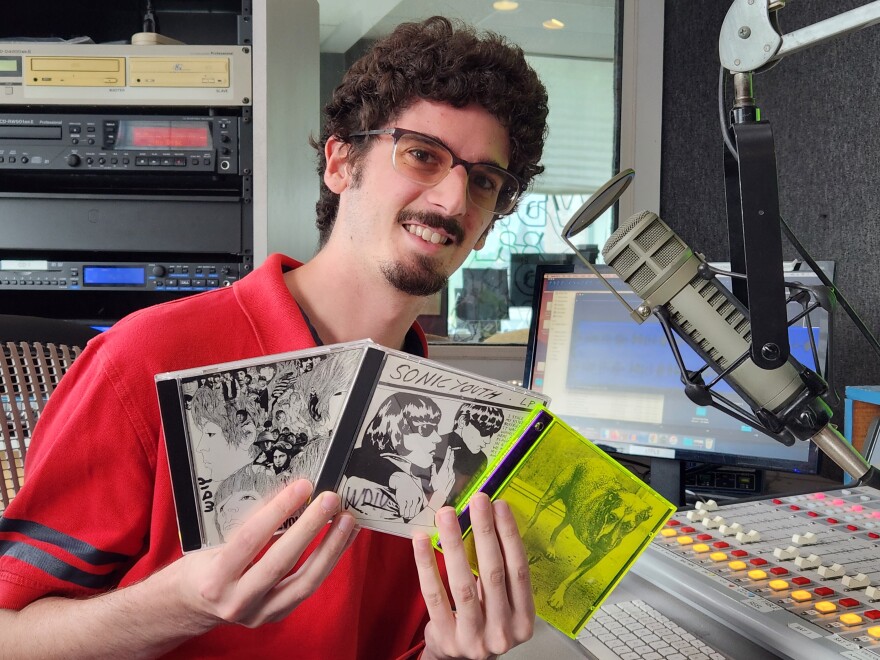  Lewis holds three CDs in his hands.