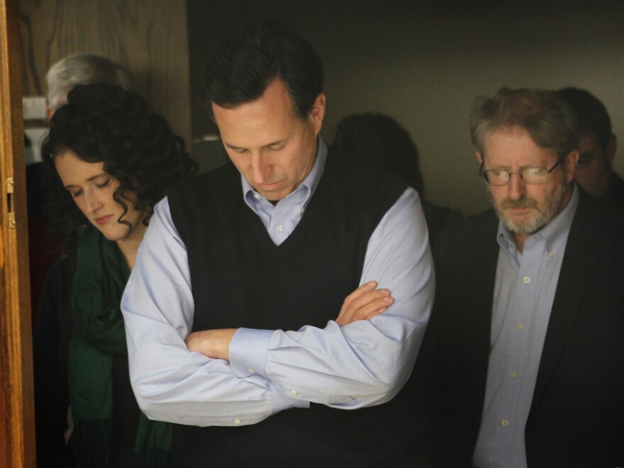 Santorum bows his head in prayer during a campaign rally in the basement of the Northwestern Bank building in Orange City, Iowa, on Jan. 1.