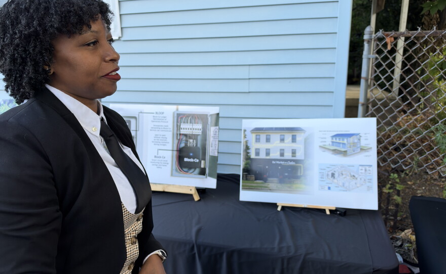 Rashida Lovely, CEO of the Afree Foundation, stands near renderings for the Welby Court Community & Resilience Affordable Housing Project in Scranton.