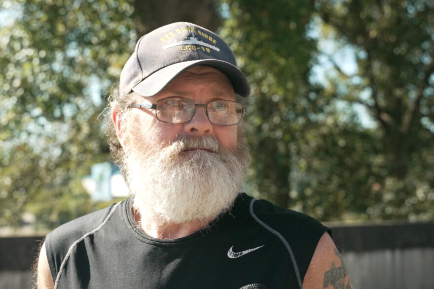 A bearded man in a sleeveless black shirt