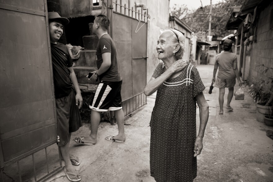 Narcisa Claveria laughs with neighbors in this 2019 photo. Even in the coronavirus pandemic, she goes out, wearing a mask. "I'd rather die in the streets," she says, "than stay dying of sadness at home."