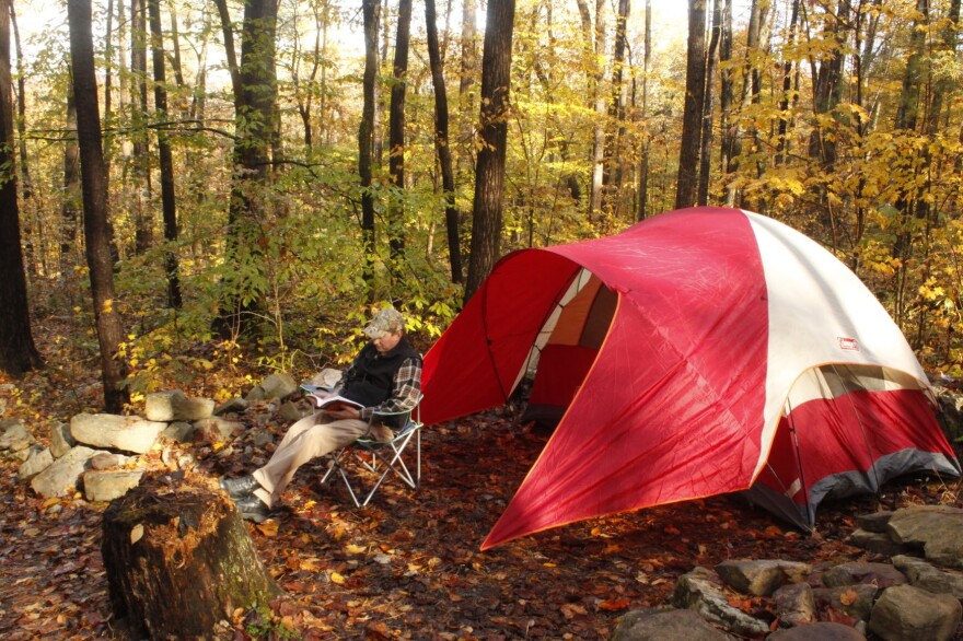 A camper reads in a chair at one of Pennsylvania's many campsites.