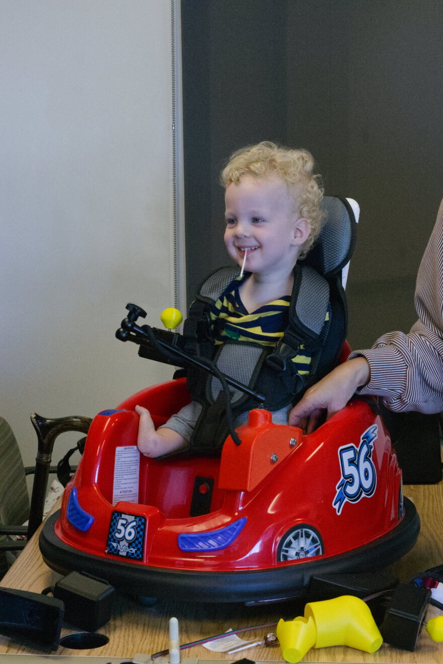 A small child tries out a new mobility device.