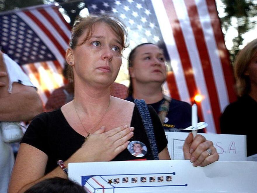 The wife of a victim of the attacks on the World Trade Center attends a candlelight vigil in New York City in 2002.