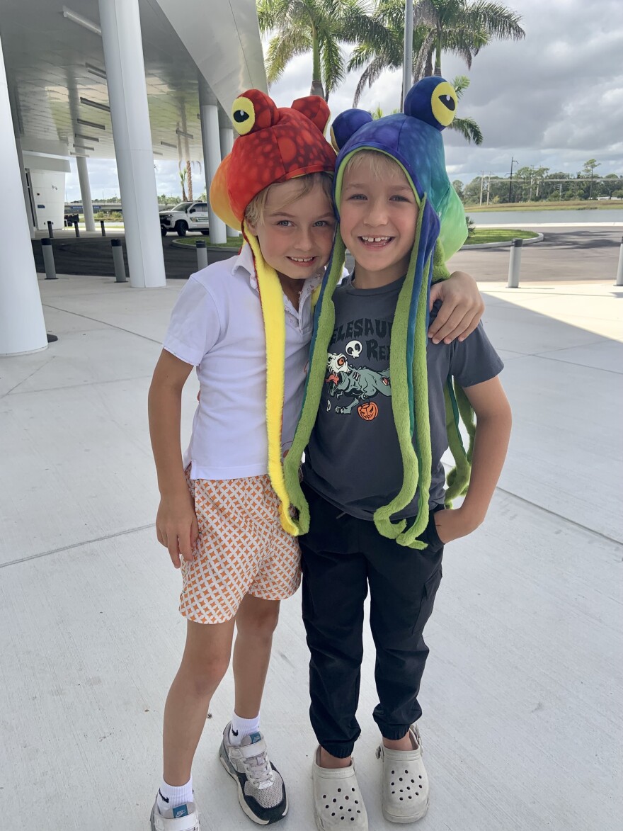 Two young boys wearing felt octupus hats smile at camera.