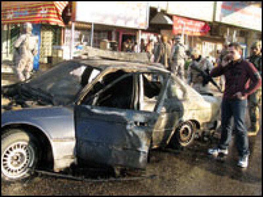 Hamdani stands beside the wreckage of NPR's armored BMW when it was blown up in 2008.