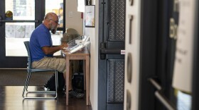 Mark Adkins, 63, Nationwide Financial CPA in compliance and ethics, works at a welcome desk that holds pamphlets at the Punta Gorda Charlotte Library on Tuesday, Oct. 11, 2022.