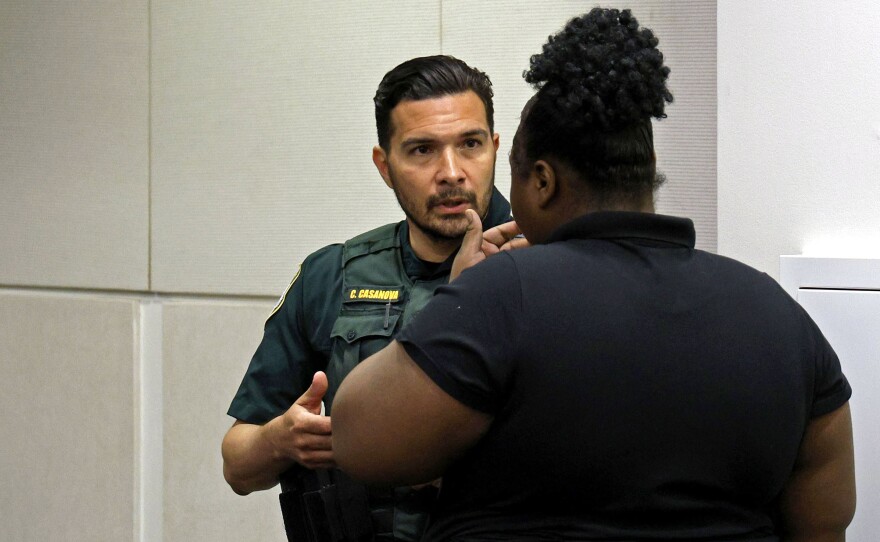 Carlos Casanova, Alachua County Sherriff’s Office resource officer at Fort Clarke Middle School, speaks with a defendant before proceedings in Teen Court at the Alachua County Criminal Courthouse on April 16. (Lee Ann Anderson/WUFT News)