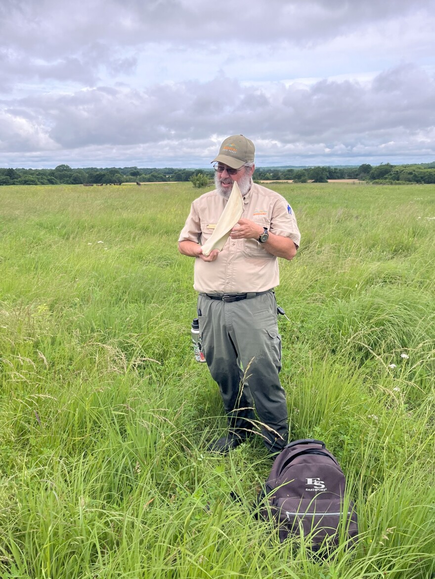 Hoisington shows visitors a shoulder blade of a bison, and tells them how Native Americans used it as a gardening hoe.