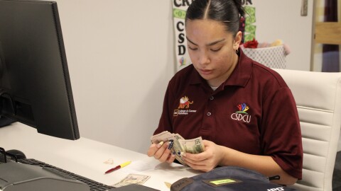 Annalisa Jacobo, a junior at Winnetonka High School, checks her coworker's bag as part of the credit union's required quarterly surprise cash counts.