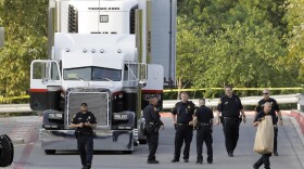 San Antonio police officers investigate the scene where eight people were found dead in a tractor-trailer loaded with at least 30 others outside a Walmart store in stifling summer heat in what police are calling a horrific human trafficking case, Sunday, July 23, 2017, in San Antonio. (Eric Gay/AP)