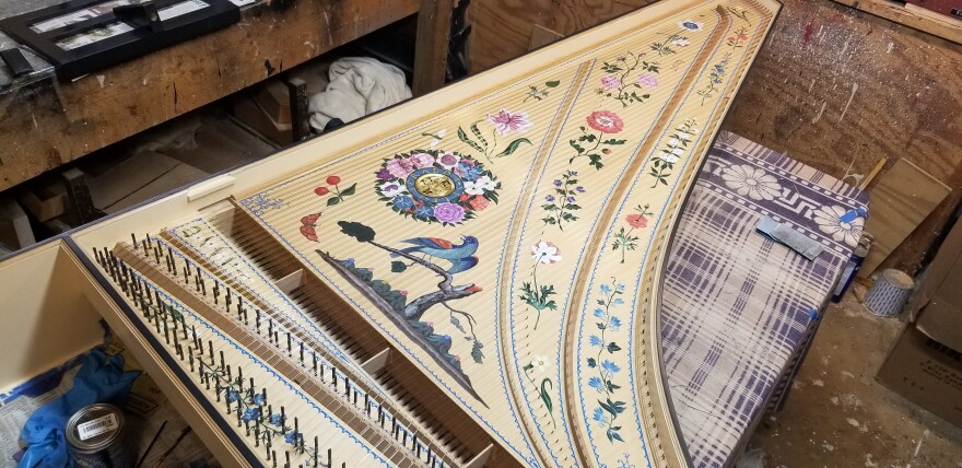 Paintings of flowers and birds populate the inside of this harpsichord case.