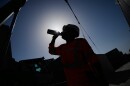 A worker drinks water on a construction site during high temperatures Wednesday, June 24, 2026. (AP Photo/Christophe Ena)