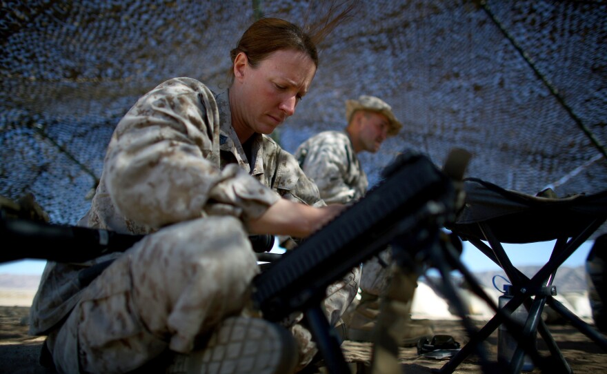 Brown, 30, cleans her weapon under the shade of camouflage netting at the Marine base at Twentynine Palms. Her grandfather's service in Korea and Vietnam inspired her to participate in this experiment.