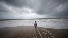 Weston Lee, of Vero Beach, stands near the high surf from the Atlantic Ocean.