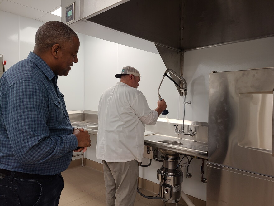 Calvin Moore (left) looks on as Jeff Marlow (right) demonstrates some of the new kitchen's features.