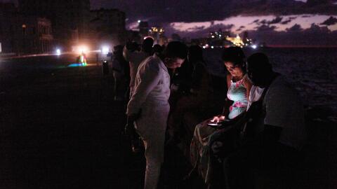 People spend the night in the dark on the Malecon during a blackout in Havana, Cuba, Saturday, March 21, 2026. (AP Photo/Ramon Espinosa)