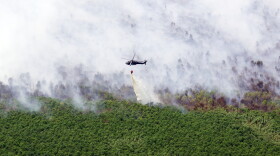 Louisiana National Guard Blackhawks douse marsh fire with 500-gallon water drops.