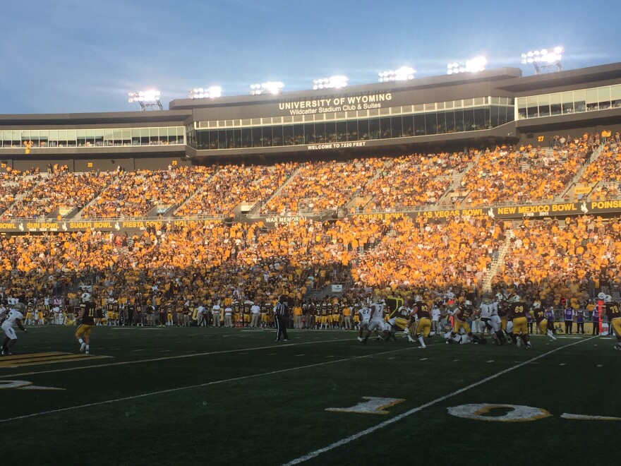 University of Wyoming Cowboys Football team playing on the field, the stadium filled with fans