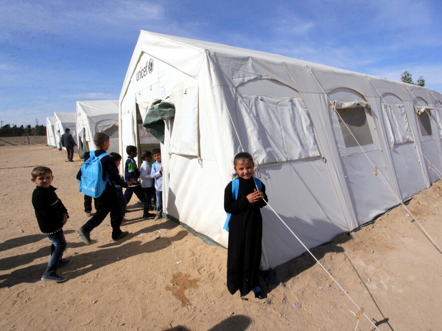 An Iraqi child, whose family fled from Islamic State violence in the northern city of Mosul, stands outside a tent that serves as a school in the southern city of Najaf on Sunday. Some 2 million Iraqis have been driven from their homes by fighting this year.