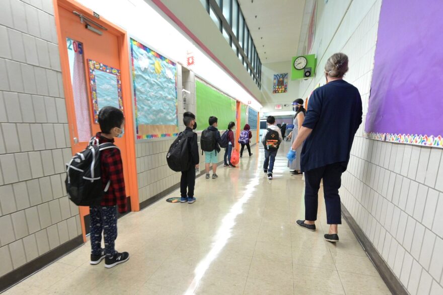 Students line up before walking into class on a day of in=person learning at Yung Wing School P.S. 124 in New York City. The start of in-person learning was delayed in New York City schools via a phased in reopening.