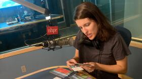 Producer Marina Henke inspects the components of the climate change board game “Daybreak.”