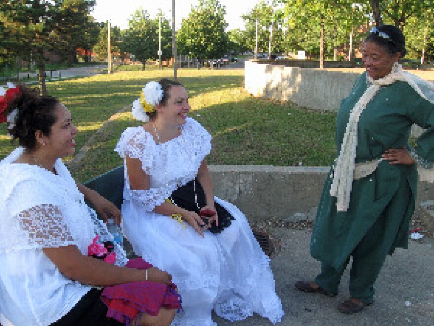 Cecilia Nadal (standing at right in green) talks with Yanith Carranza (left) and Elizabeth Morales in Amherst Park after the unity concert. Morales came from the Festival of Nations in Tower Grove Park. 