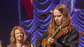 Billy Strings performs in the finale of the IBMA Awards, with singer Patty Loveless looking on.