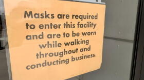 Signs posted at entrances to the Statehouse tell visitors they must wear masks inside.