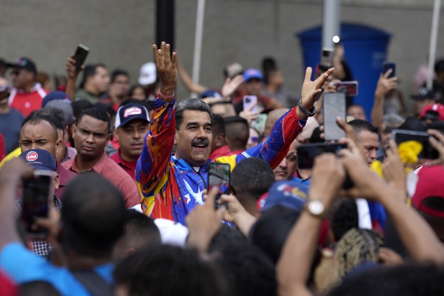 Venezuelan President Nicolas Maduro greets a crowd of young supporters. 