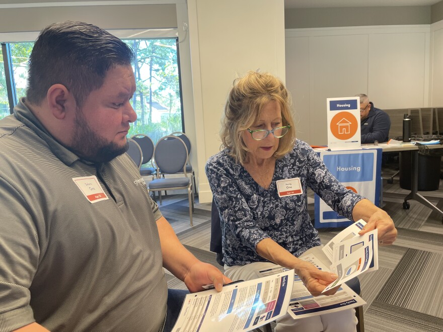 Juan Lopez and Susan Ugell check out their family description in the Cost of Poverty Experience.