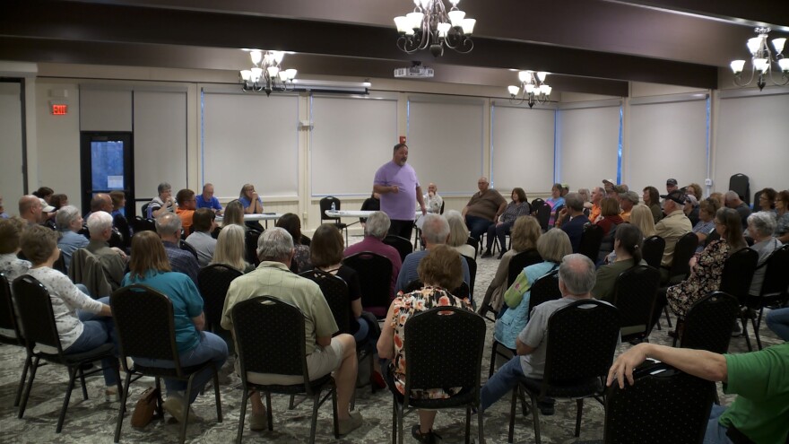 A man standing in the middle of a crowded room.