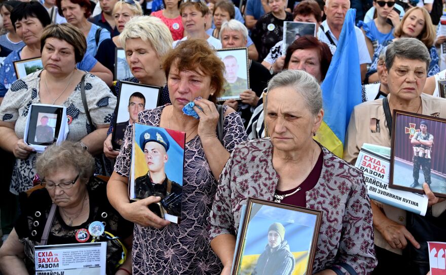 Mothers and widows of Ukrainian servicemen hold pictures of their relatives during a memorial rally in front of the Russian embassy in Kyiv, Ukraine's capital, in August.