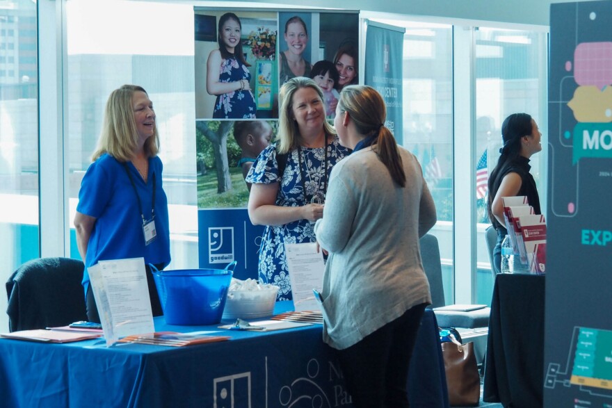 Representatives for the Goodwill Nurse-Family Partnership speak with a summit attendee on Tuesday, during the Labor of Love Summit at the JW Marriott Indianapolis.