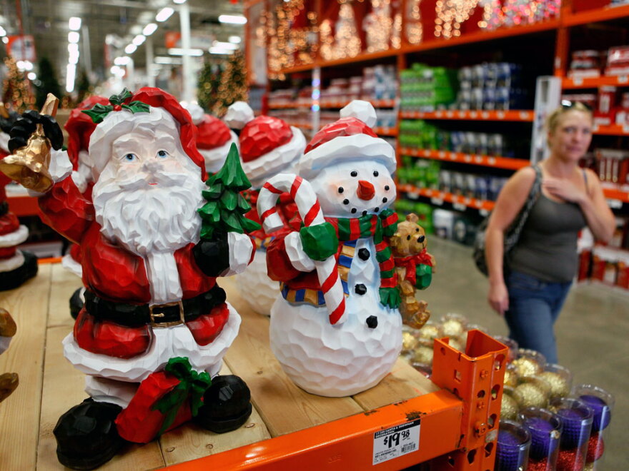 A woman walks by Christmas merchandise offered for sale in October at a Home Depot in Niles, Ill. Analysts predict the troubled economy will result in flat retail sales this holiday season.